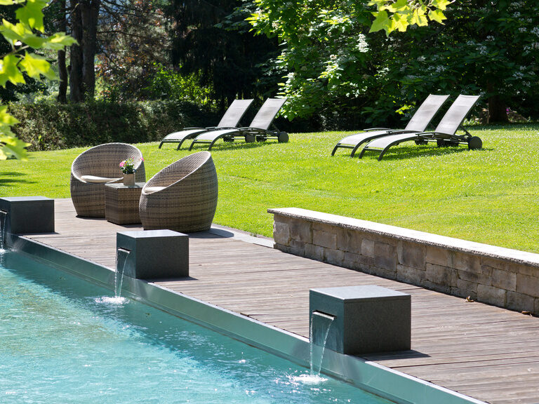 Der große Aussenpool mit ausreichend Sitz- und Liegemöglichkeiten für die Gäste des Waldhotels Grüner Baum im mittleren Schwarzwald