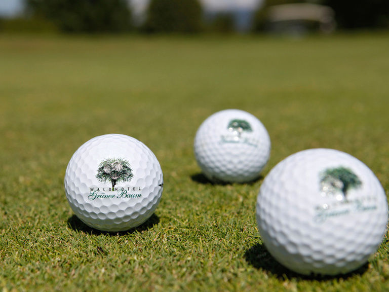 Drei Golfbälle liegen auf dem perfekt gestuzten Rasen eines Golfplatzes im Schwarzwald bei Oberkirch.