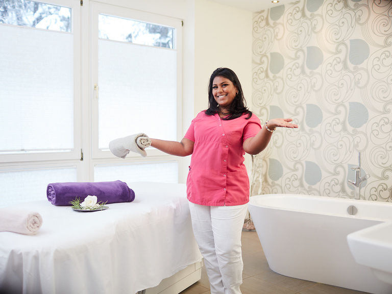 Eine Frau steht vor einer weißen Badewanne im Wellness-Zimmer des Wellnesshotels im Schwarzwald.