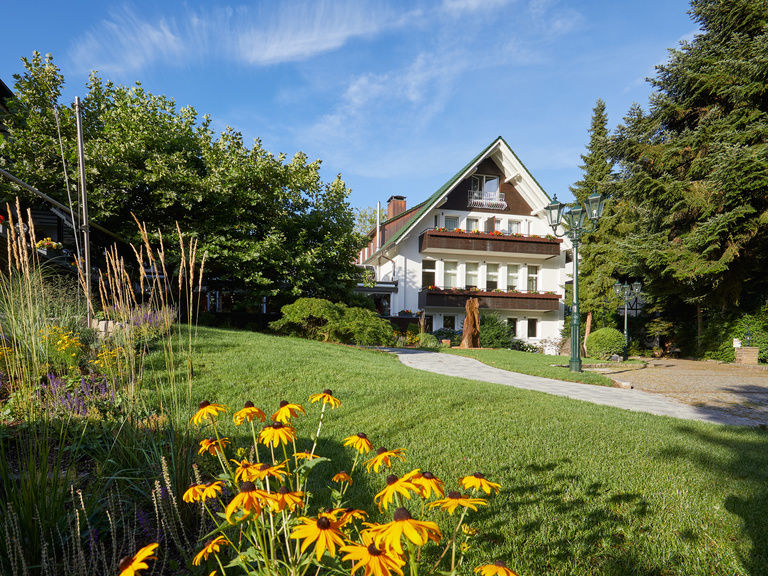 Gelbe Blumen vor dem charmanten Gebäude des Waldhotels Grüner Baum im mittleren Schwarzwald