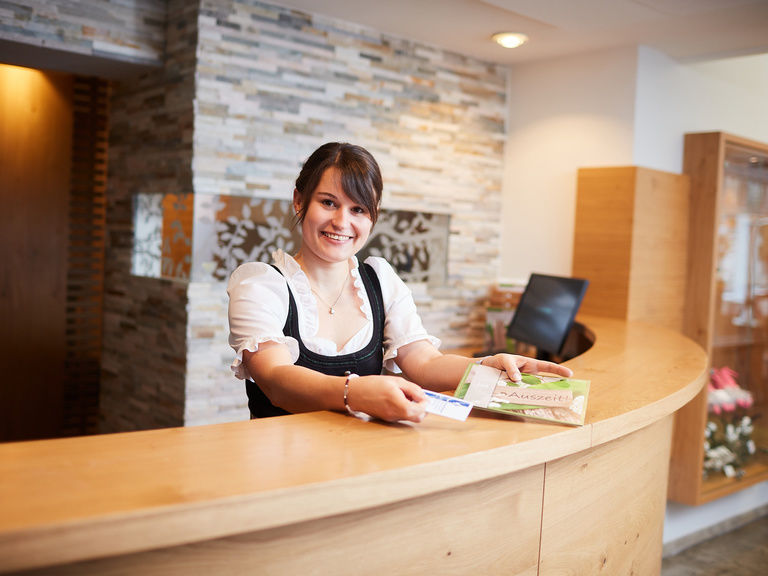 Eine lächelnde Rezeptionistin im Waldhotel Grüner Baum.