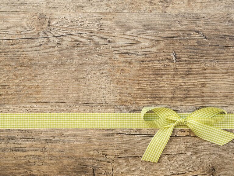 Ein Holzbrett ist mit einer Schleife geschmückt.
