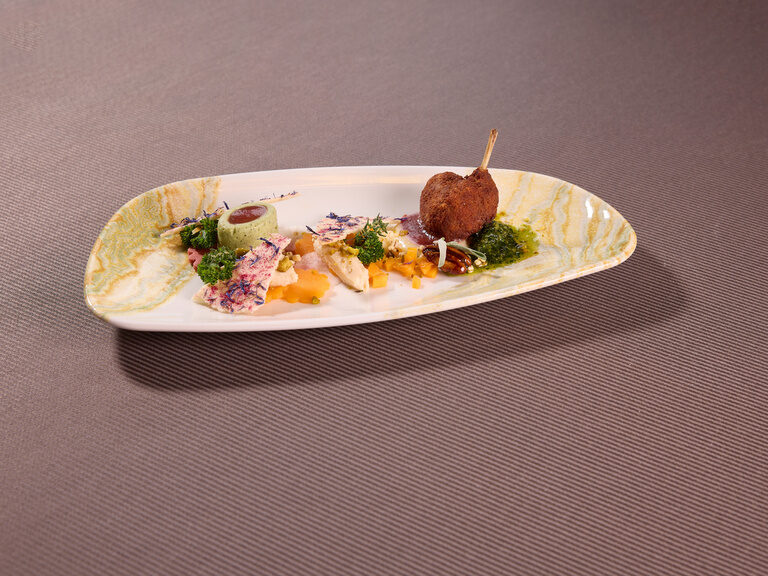 Ein kunstvoll angerichteter Teller im Restaurant präsentiert saftiges Fleisch mit knackigem Gemüse.