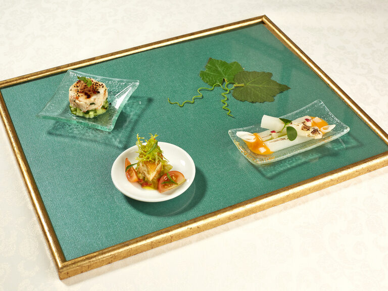 Ein Tablett mit kunstvollem Blumendesign trägt verschiedene Speisen.