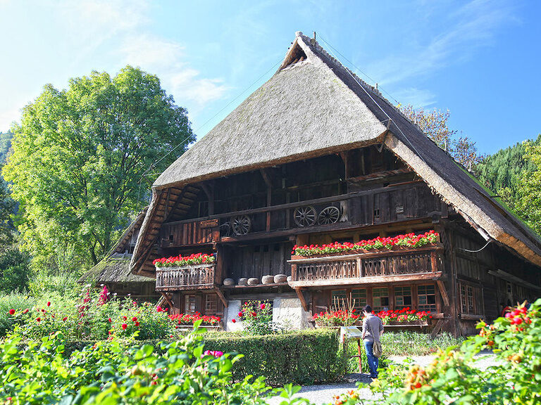 Das grosse Fachwerkhaus des Vogst Bauernhofes umgeben von herrlichen Blumenbeeten.