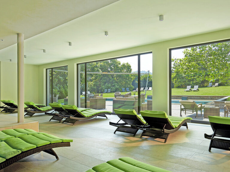 Die grünen Liegen im Poolbereich des Waldhotels Grüner Baum bieten den perfekten Ort für Ruhe zwischen Bade-Sessions