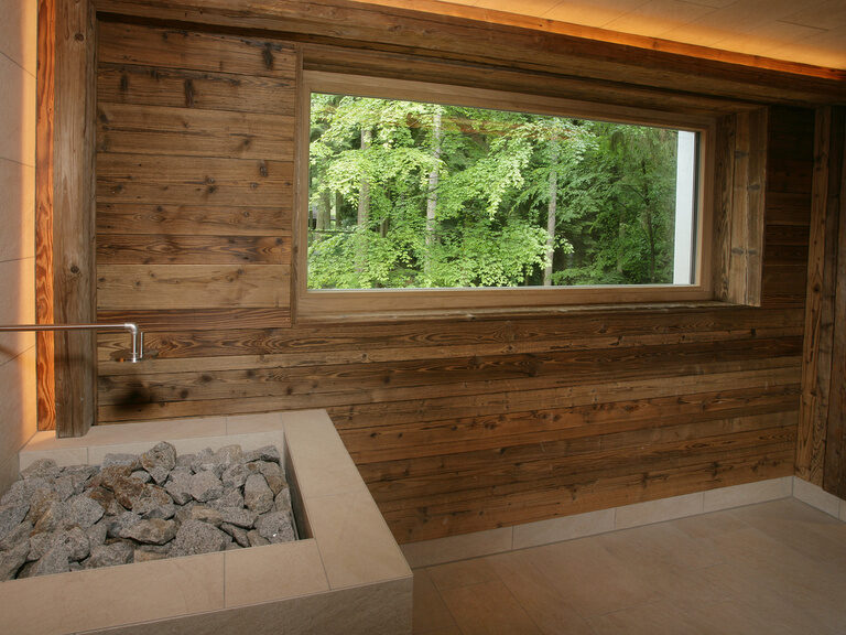 An die Wand der Panoramasauna des Waldhotels Grüner Baum im mittleren Schwarzwald wurde ein Wasserhahn über den Ofen gebaut um automatische Aufgüsse zu machen und damit jederzeit die perfekte Saunaumgebung beizubehalten.