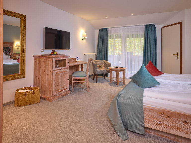 Ein gemütliches Komfortzimmer mit einem großen Bett und einem Flachbildfernseher an der Wand.