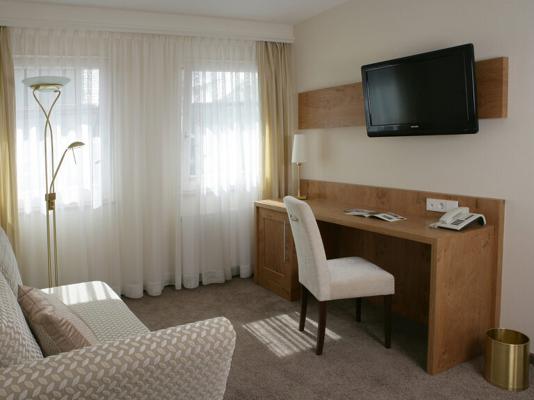 Ein stilvolles Arbeitszimmer mit einem Schreibtisch, Stuhl und Fernseher in der Studio Suite..