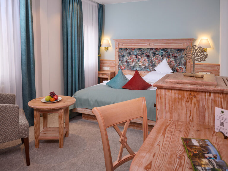 Ein stilvoll eingerichtetes Standartzimmer im Waldhotel Grüner Baum mit luxuriösem Bett und entspannter Beleuchtung.