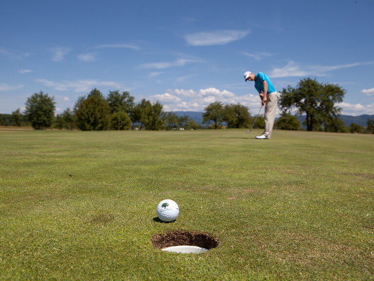 Ein Mann verfehlt knapp das Loch bei Golfen im mittleren Schwarzwald