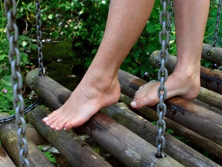 Eine Person überquert eine Brücke in einem Barfußpark im mittleren Schwarzwald