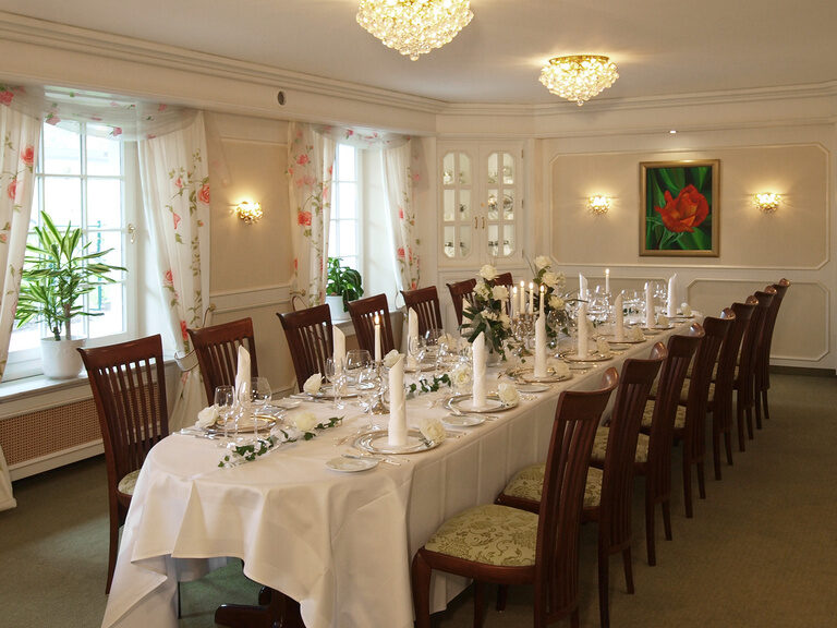 Ein langer Esstisch in einem stilvollen Restaurant mit edler Beleuchtung.