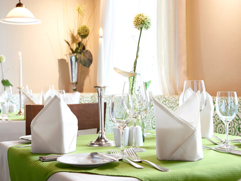 Ein geschmackvoll gestalteter Tisch mit grüner Tischdecke im Restaurant des Hotels im Renchtal