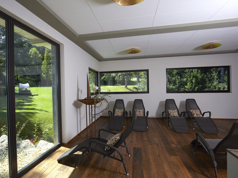 Der Ruheraum mit seinen komfortablen Liegen ist der perfekte Platz um nach einem Saunagang zu entspannen und bietet eine schöne Aussicht in den Garten.