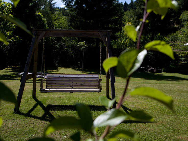 Eine Schaukel im Garten des Waldhotels Grüner Baum bietet einen gemütlichen Platz zum Schaukeln und Sitzen