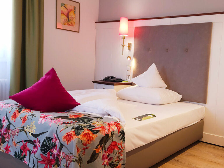 Ein stilvoll eingerichtetes Zimmer mit einem gemütlichen Bett im Hotel Grüner Baum.