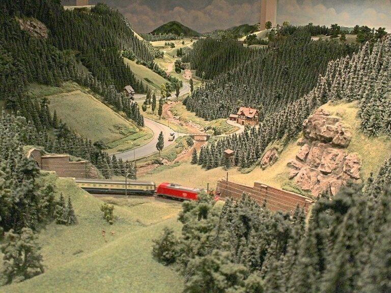 Die Umgebung in einem Modellbahn-Bau zeigt eine winterliche Umgebung mit großen Wäldern.