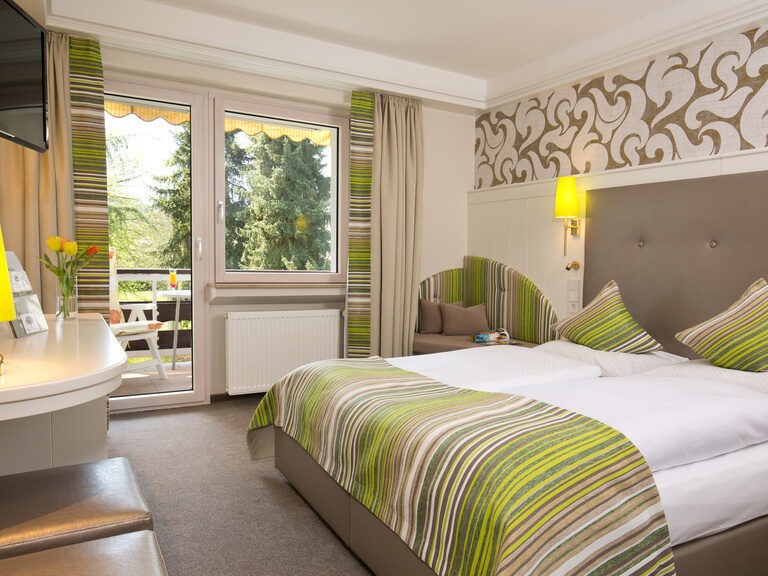 Das Standartzimmer im Waldhotel Grüner Baum bietet unter anderem einen Flatscree-TV und kostenloses WLAN vereint mit eine stylischen Zimmer und schönem Ausblick