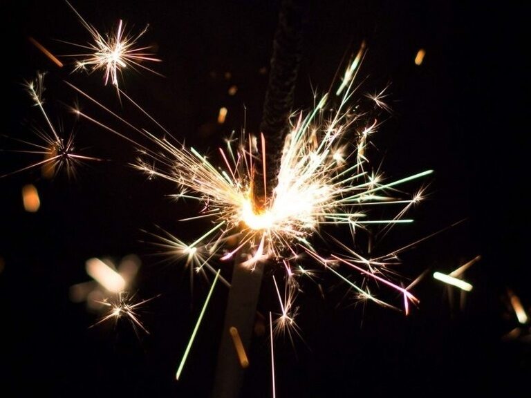 Ein funkelnder Wunderkerzenstab erleuchtet die Dunkelheit an Silvester im Schwarzwald
